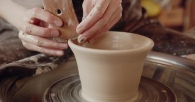 Stüdyoda el yapımı bardak alan profesyonel bir seramistim. Seçici bir odak noktası. Stüdyoda el işi çanak çömleği şekillendiren kadın çömlekçi elleri. Sanat ve küçük işletme kavramı 