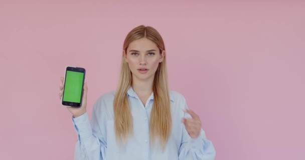 Aantrekkelijke Prachtige Jonge Vrouw Wijzend Naar Smartphone Met Kopieerruimte Voor — Stockvideo