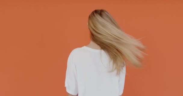Молодая Женщина Длинными Волосами Белой Футболке Стоящей Спиной Камере Обернувшись — стоковое видео