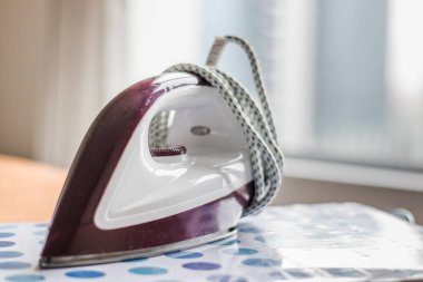 Odanın ütü masasında elektrikli bez ütü var.
