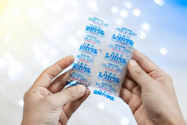 Desiccant Silica gel bag on hand with white light backgrounds