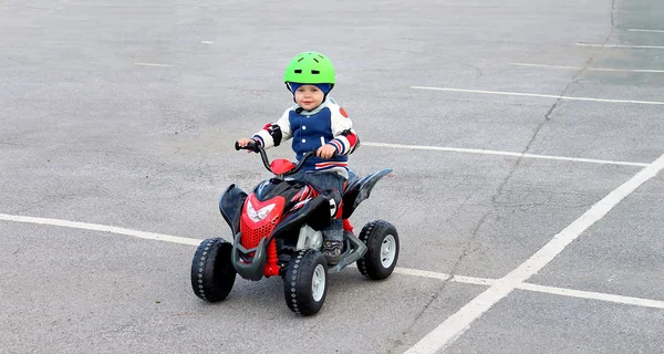 Мальчик в защитном шлеме на электромобиле — стоковое фото