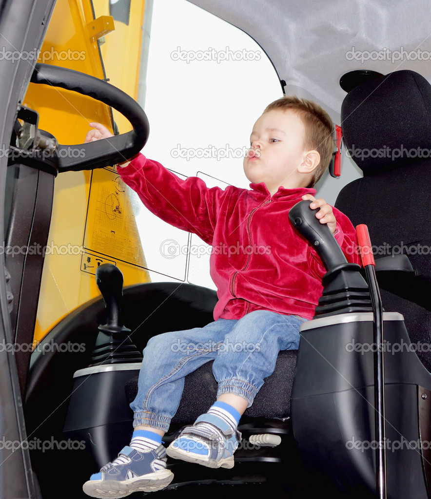 Boy at the wheel of excavator
