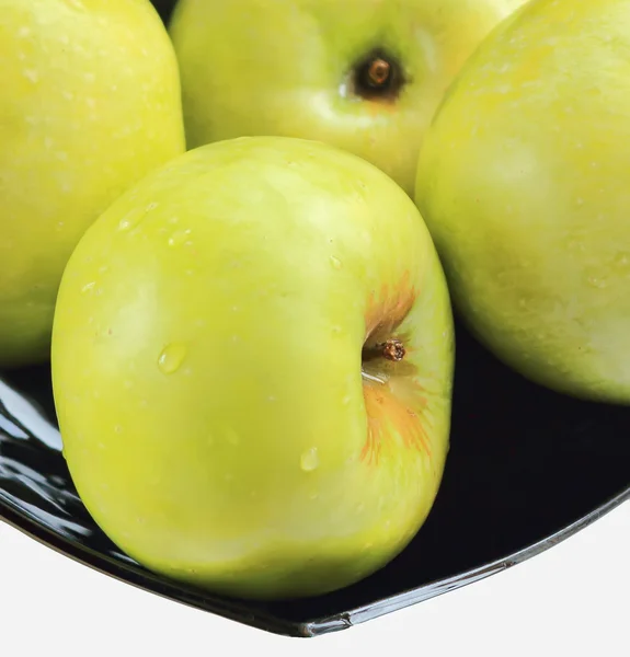 Green apples on a black plate — Stock Photo, Image
