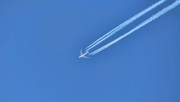 Plane in the sky draws strip