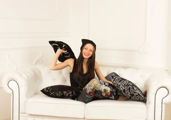 Giovane donna su un divano — Foto Stock