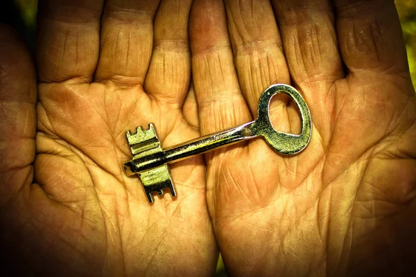 Ключ в руках літньої людини — стокове фото