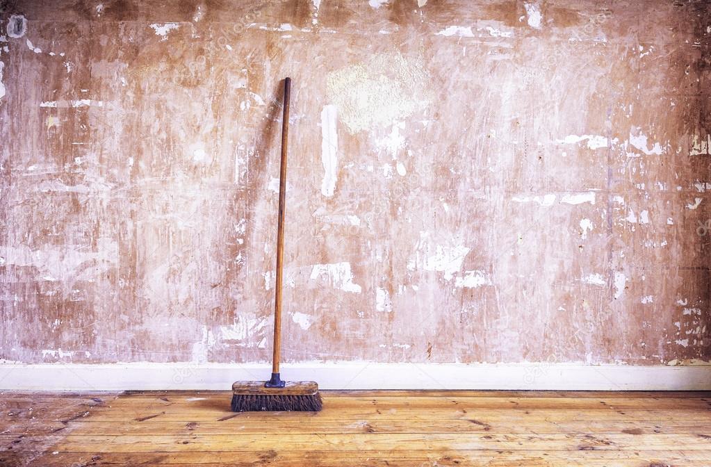 Broom against stripped drywall