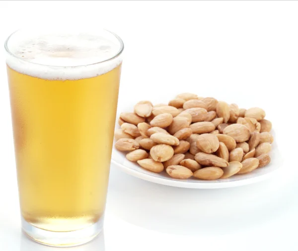 Appetizer with beer and fried, peeled almonds. Royalty Free Stock Images