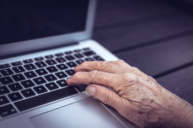 yaşlı insanların elleri dizüstü bilgisayarın klavyesinde