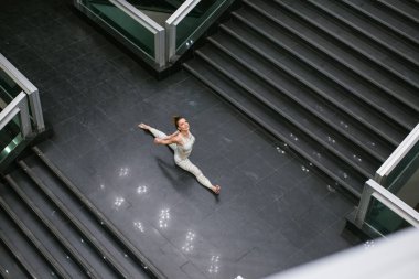 Yukarıda merdivenlerde yoga yapan bir kadın var.