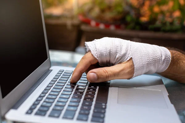 person with injured wrist typing on laptop