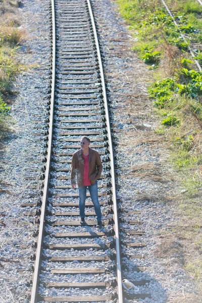 一个孤独的人站在铁轨上 — 图库照片