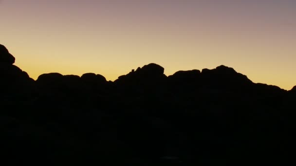 Coucher de soleil s'estompant sur les roches — Video