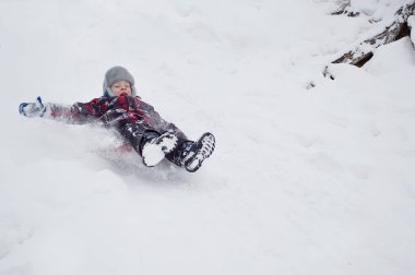 Beyaz pofuduk kar üzerinde kış eğlence treni yolculuğu. Mutlu bir çocuk sevinçle çığlıklar atar. Mutlulukla dağın tepesinden aşağı yuvarlanır.