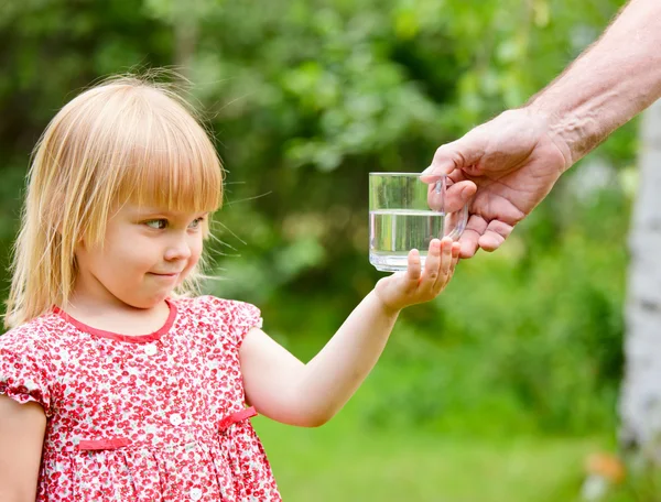 Bambina con prendendo il bicchiere d'acqua — Foto Stock