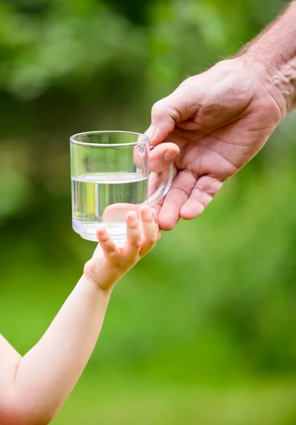 Liten flicka med ett glas vatten från morfar — Stockfoto