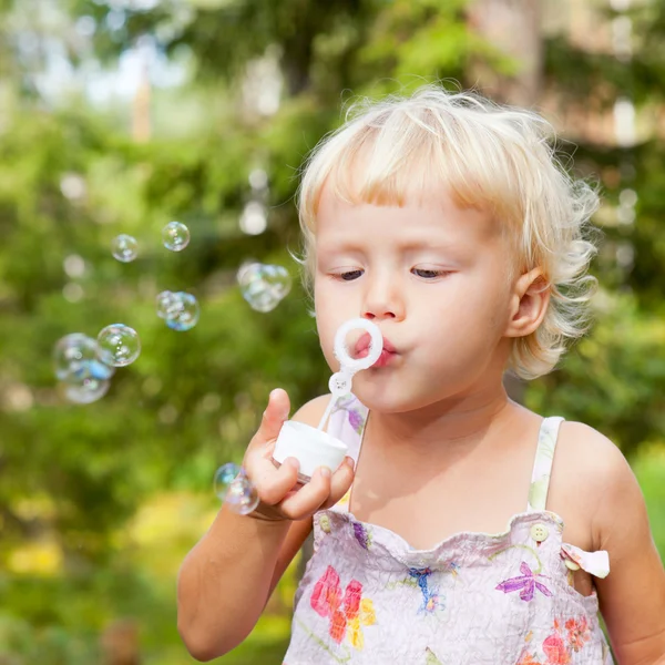 Маленькая девочка делает пузыри — стоковое фото