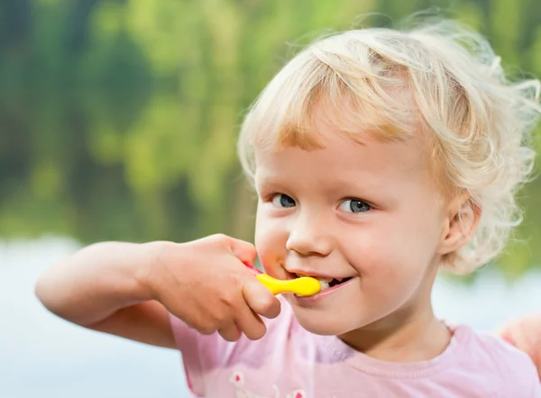 Blonde girl brushing teeth — Stock Photo, Image