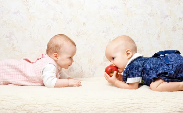 Два младенца с яблоком — стоковое фото