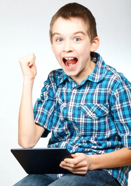 Boy cheering holding tablet computer — Stock Photo, Image