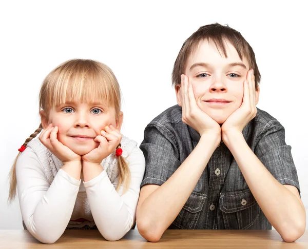 Sister and brother sitting at desk — Stock Photo, Image