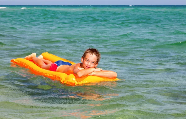 Boy on a inflatable mattress — Stock Photo, Image