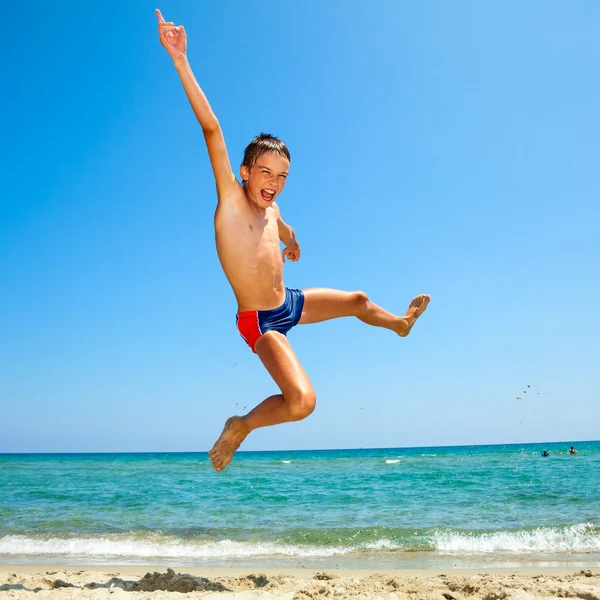 Jongen springen op het strand — Stockfoto