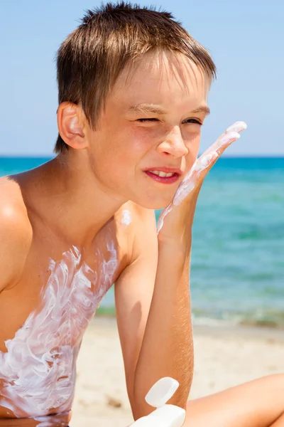 Jongen toepassen zonnebrandmiddelen — Stockfoto