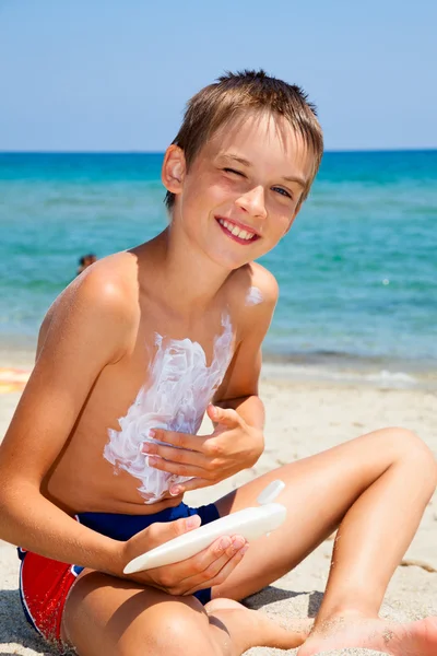 Jongen toepassen zonnebrandmiddelen — Stockfoto