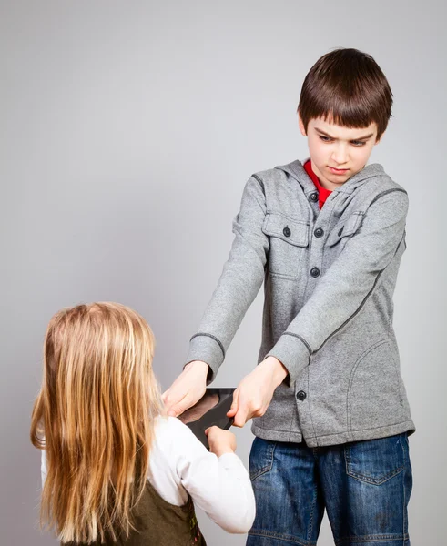 Children fight for tablet computer — Stock Photo, Image