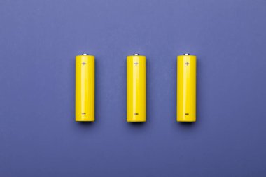 2022 yılının mavi modayı üzerine üç sarı AA alkali pilin veya NiMH şarj edilebilir hücrelerin üst görünümü