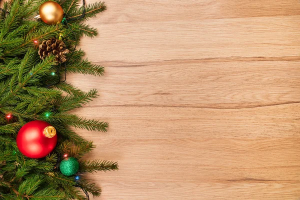 木製ボード上のモミの枝の泡やライトとクリスマスの背景 — ストック写真