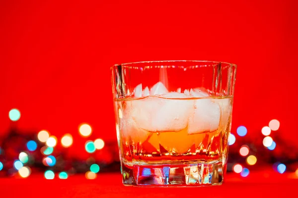 Close Shot Glass Whiskey Rocks Christmas Lights Red Background Christmas — Stock Photo, Image