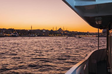 Yolcu feribotundan gün batımında İstanbul Boğazı 'ndan İstanbul Boğazı' nı geçeceğiz. Eminonu ilçesi arka planda görülüyor