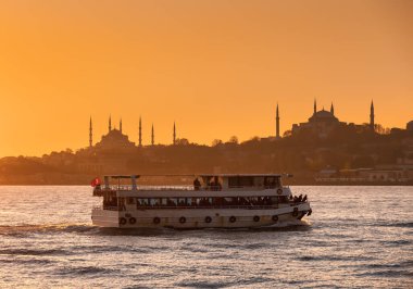 Feribotla İstanbul Boğazı 'ndan geçen yolcu feribotu gün batımında. Arka planda Sultan Ahmed Camii ve Ayasofya görülüyor