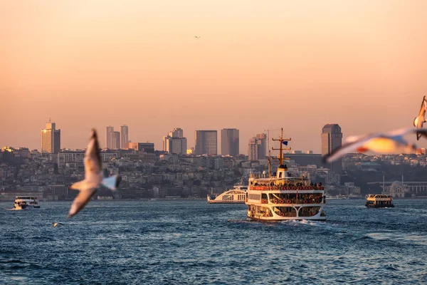 İstanbul Boğazı 'ndan gün batımında feribotla geçen yolcu. Arka planda Beyoğlu ilçesi görülüyor
