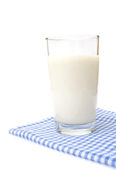 Een glas melk op geruite handdoek, geïsoleerd op de witte. — Stockfoto