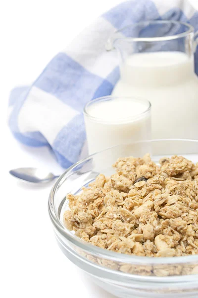 Primer plano de un tazón de cereal con una jarra de leche fresca, aislado — Foto de Stock