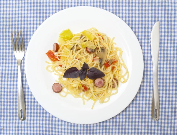 Espaguetis con calabacín, champiñones, salsa, queso, salchichas en una p — Foto de Stock