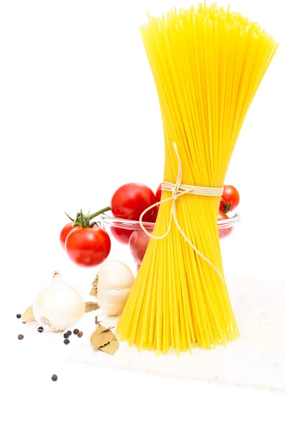 Spaghetti, cherry tomatoes, onions, garlic, bay leaf, pepper on — Stock Photo, Image