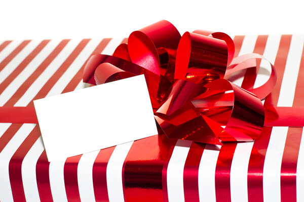 Подарок с лентой и биркой. Изолированный на белом фоне
