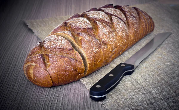 Frisches, schmackhaftes Brot auf holzigem Hintergrund — Stockfoto