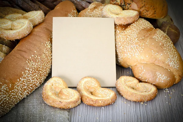 Pão saboroso fresco em fundo lenhoso — Fotografia de Stock