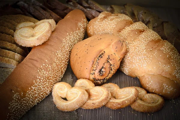 Pane fresco e saporito su sfondo legnoso — Foto Stock