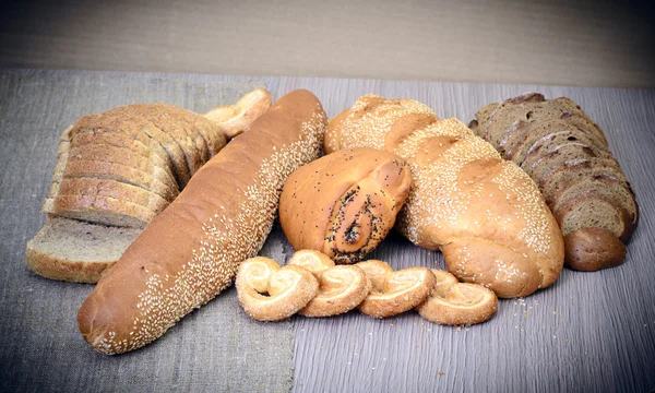 Pão saboroso fresco em fundo lenhoso — Fotografia de Stock