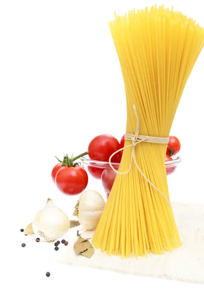 Spaghetti, cherry tomatoes, onions, garlic, bay leaf, pepper on — Stock Photo, Image