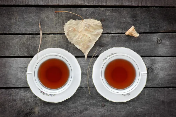 Autumn tea for two in vintage white cups on wood — Stock Photo, Image