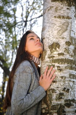 güzel kadın gökyüzünü izlerken bir huş ağacı üzerinde doğru eğildi.