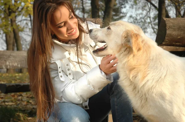 Hermosa joven con perro blanco — Foto de Stock